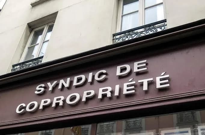 Enseigne « Syndic de copropriété » sur la devanture d’un immeuble ancien